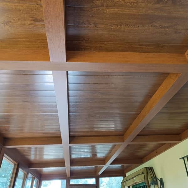 Detalle interior de cubierta aislante con acabado madera en cerramiento de aluminio